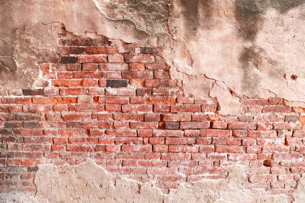 Fotobehang Muur bedekt met afbrokkelende bakstenen