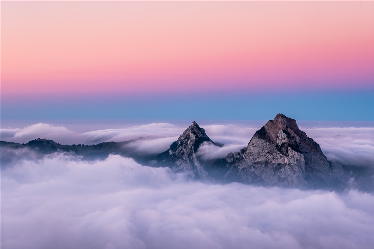 Fotobehang wolkentoppen onder een roze hemel