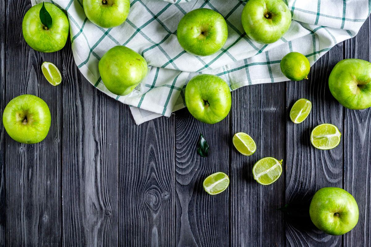 Fotobehang limoenen en groene appels staan op tafel