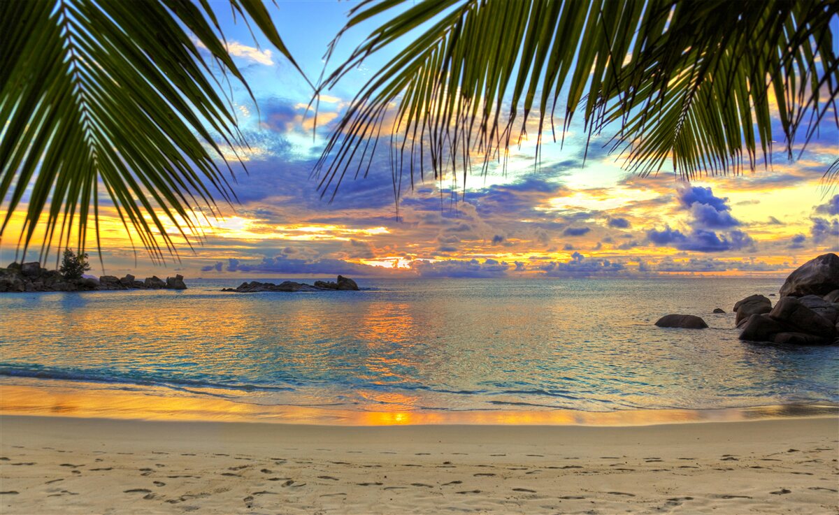 Fotobehang de kust is omgeven door een vredige tropische zonsondergang