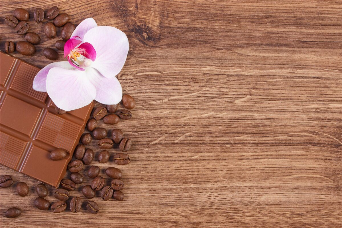 Fotobehang sneeuwwitte orchidee gedoopt in koffie en chocolade