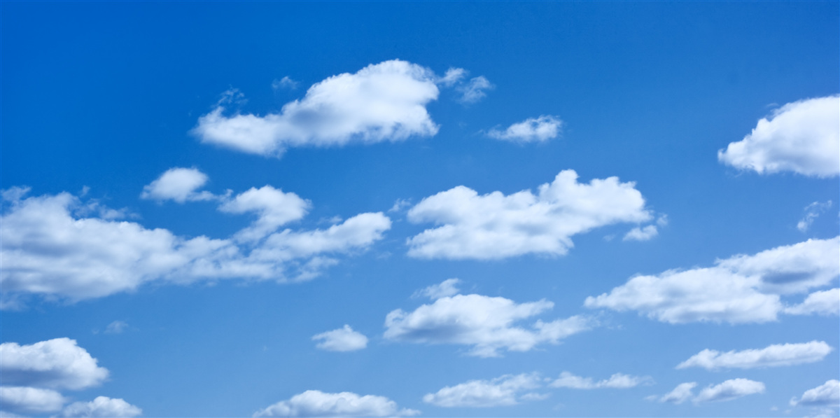 Fotobehang witte wolken drijvend in een blauwe lucht