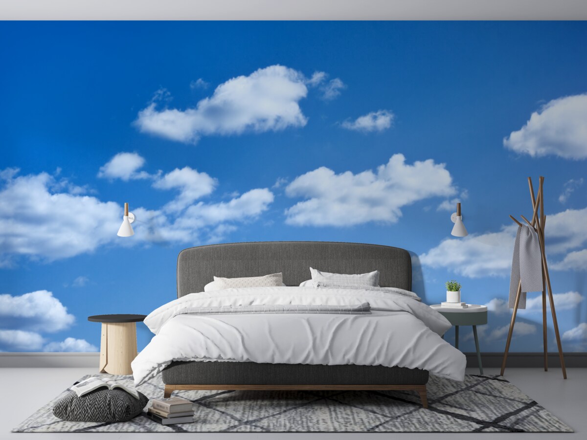 Fotobehang witte wolken drijvend in een blauwe lucht