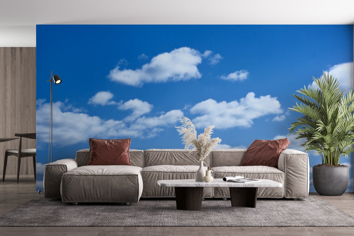 Fotobehang witte wolken drijvend in een blauwe lucht