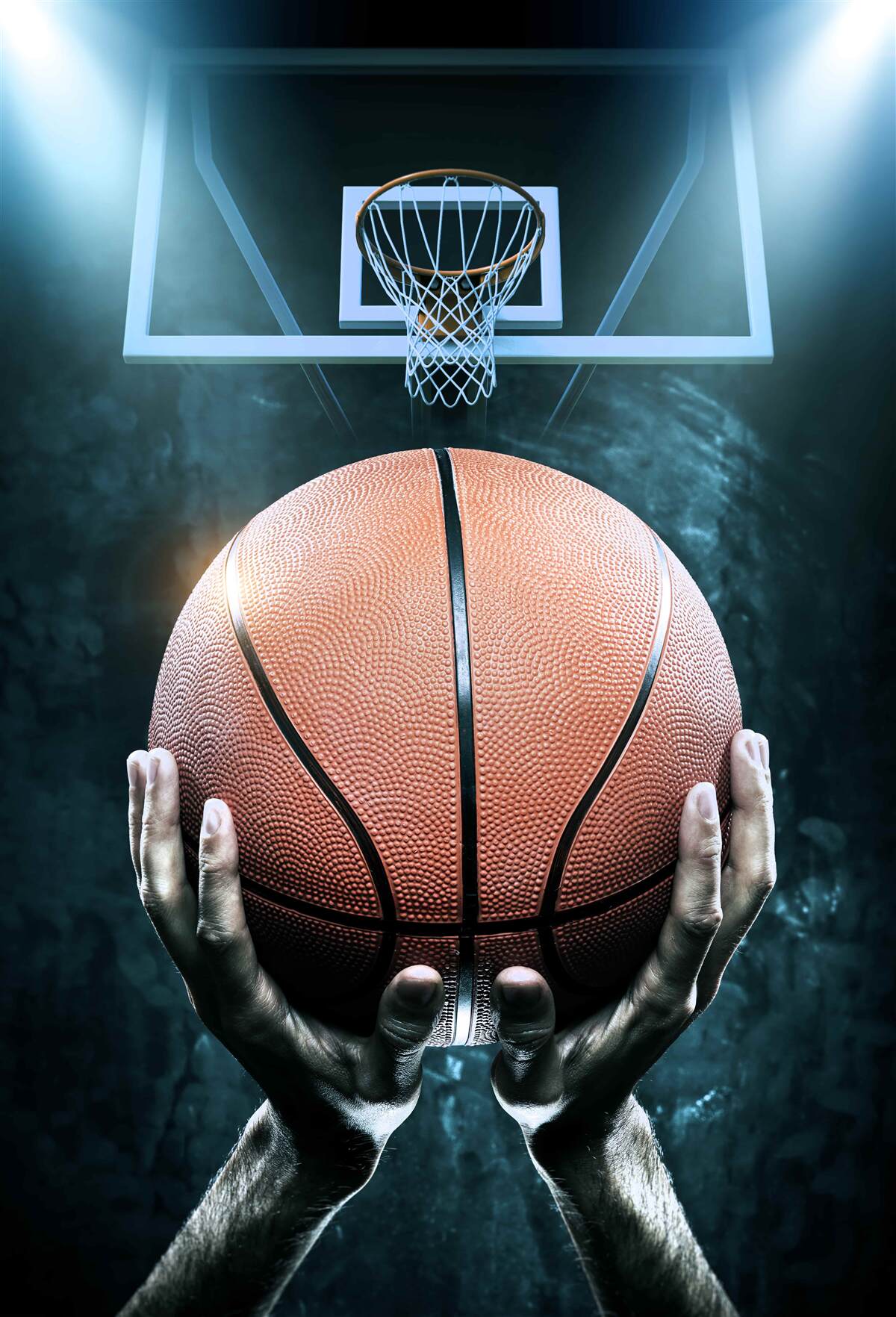 Fotobehang een basketbal wordt vastgehouden op de achtergrond van de hoepel
