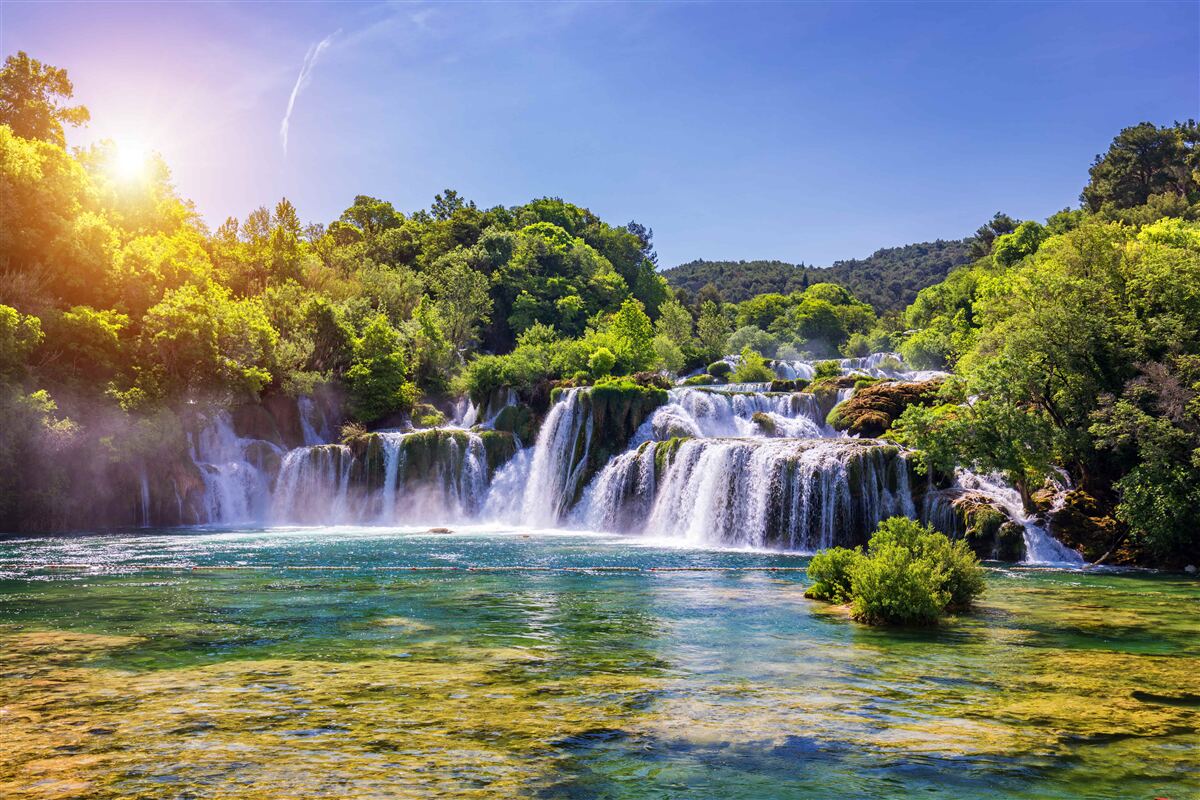 Fotobehang de waterval, die het water ruist onder de vallende schemering, maakt een luid geluid