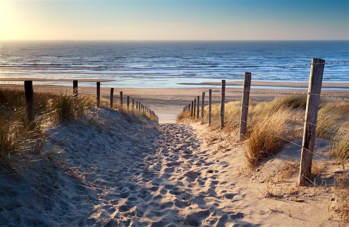 Fotobehang kalme oceaan en strand met fijn zand