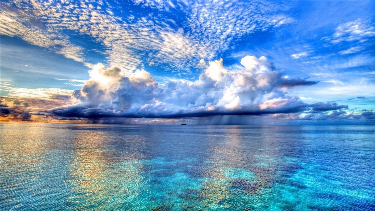 Fotobehang wolken drijven zachtjes over het blauwe wateroppervlak