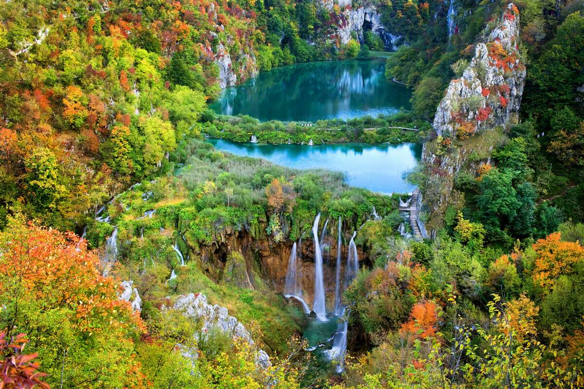 Fotobehang herfstbos versierd met een stromende waterval