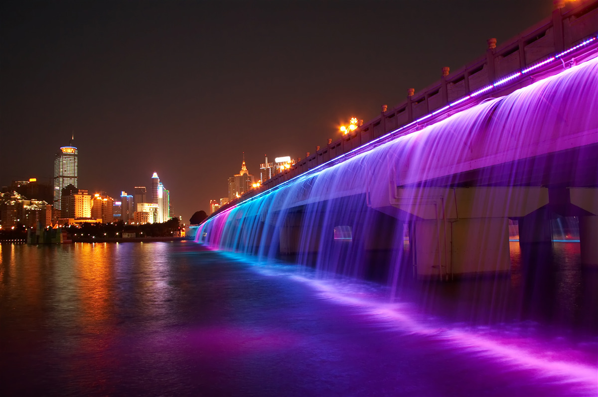 Fotobehang lichtgevende waterverlichting bij de brug