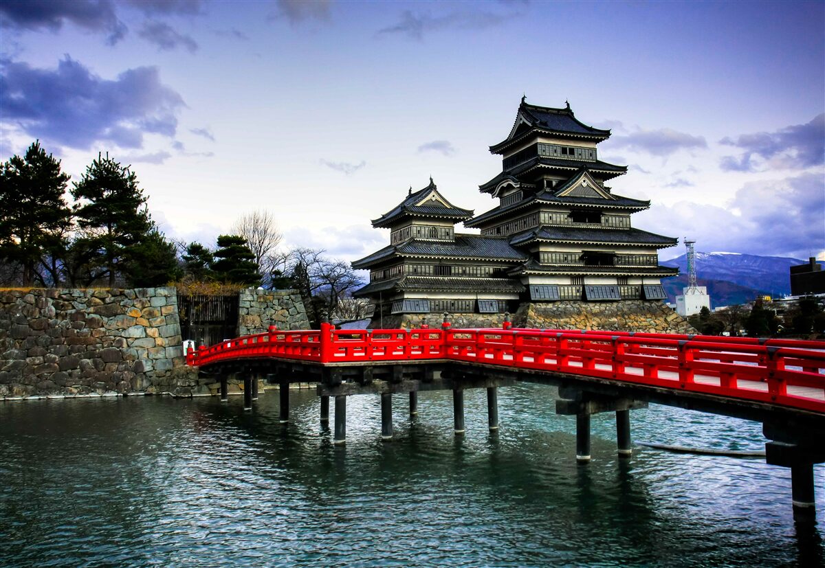 Fotobehang in japan overspant een rode brug een rivier