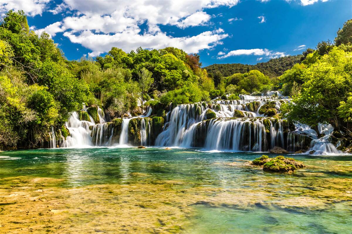 Fotobehang een enorme waterval die neerstort op een tropisch eiland